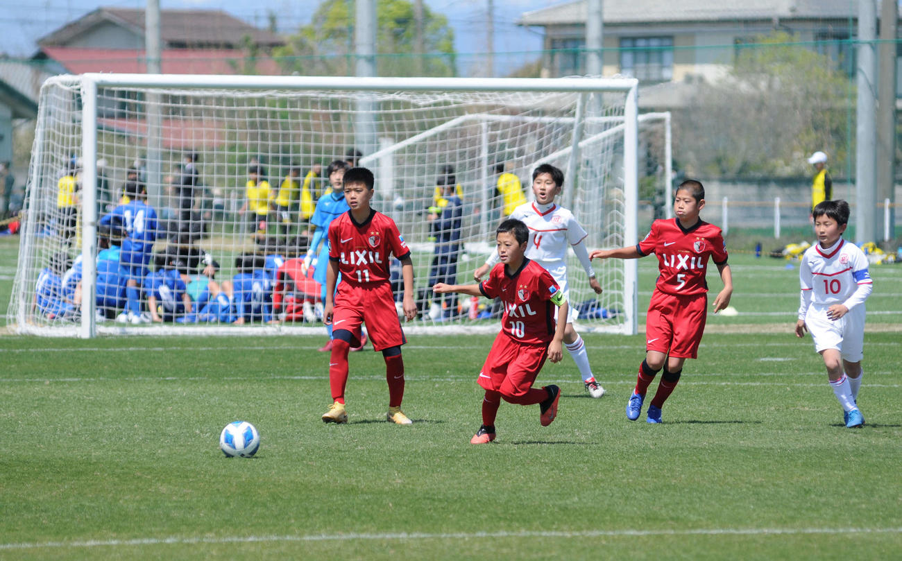 予選リーグでプレーする鹿島アントラーズジュニアと三菱養和サッカークラブ巣鴨ジュニアの選手たち