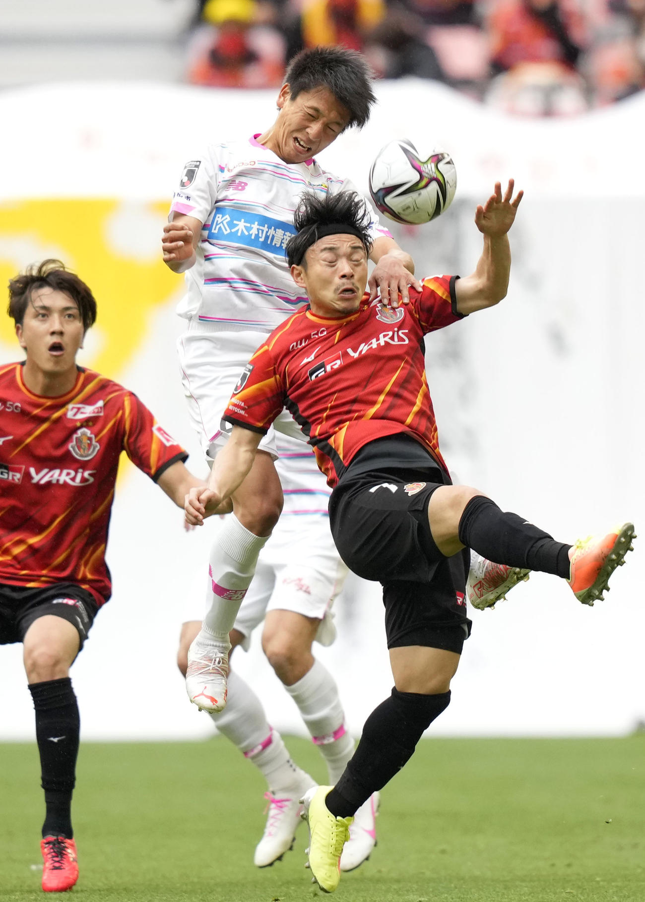 名古屋対鳥栖　前半、空中で競り合う鳥栖・松岡（上）と名古屋・阿部（共同）