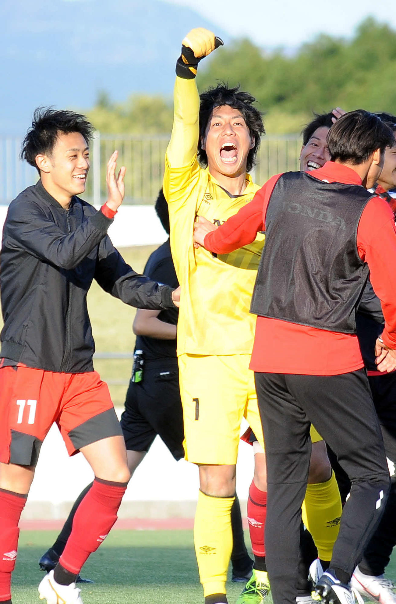 試合後、スタンドに向かってガッツポーズをするホンダFCのGK楠本（中央）