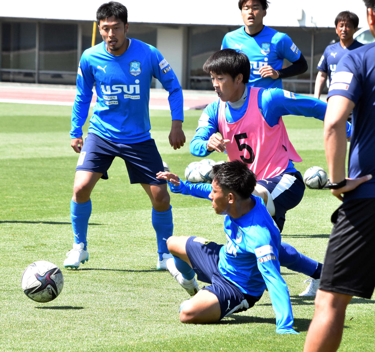 球際で競り合う沼津の選手たち。ピンク色のビブスがMF菅井