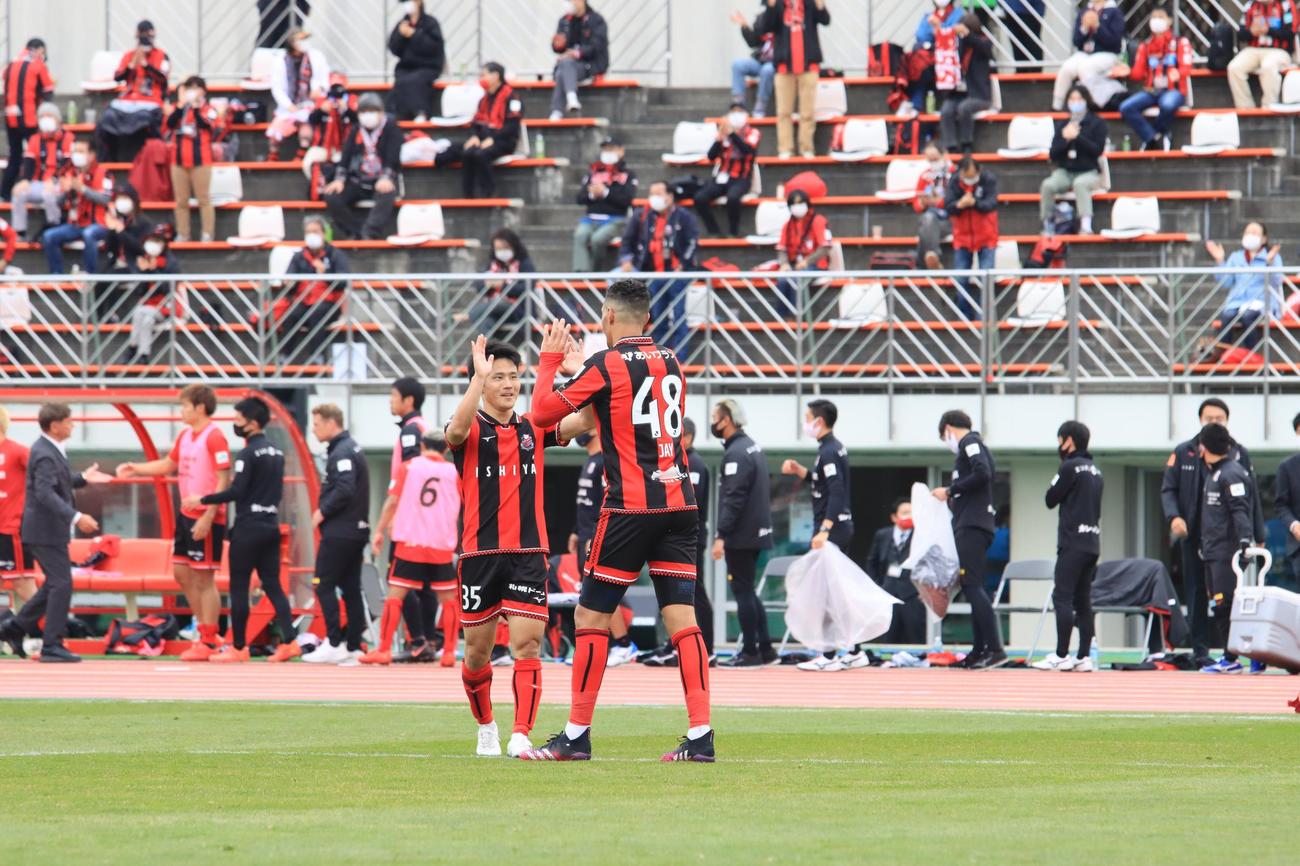 勝利が決まり、ハイタッチで喜ぶ札幌小柏（左）とジェイ（撮影・保坂果那）