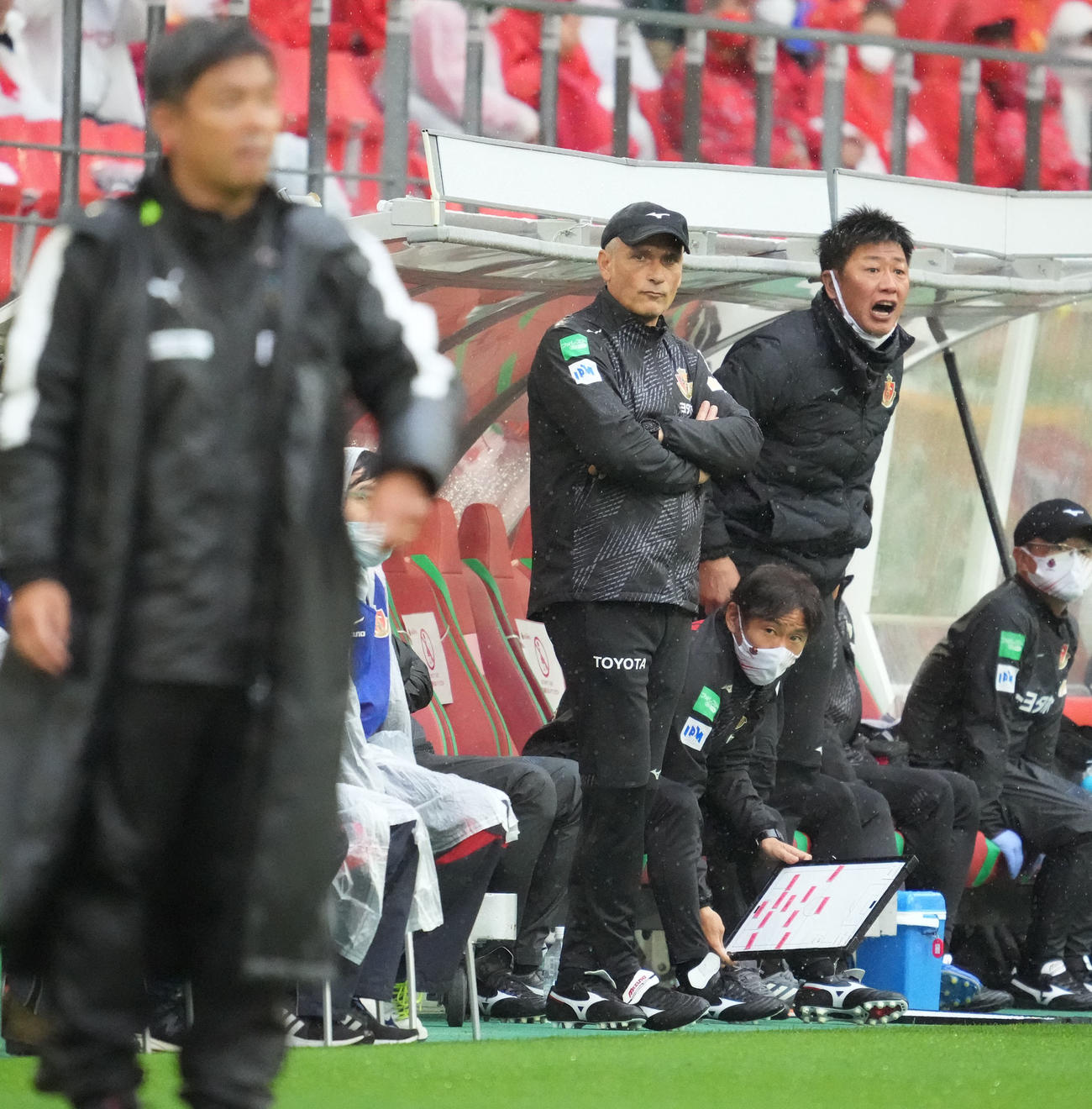 名古屋対川崎　後半、試合を見つめるフィッカデンティ監督に代わり、この試合の指揮をするブルーノ・コンカコーチ（中央）（撮影・森本幸一）