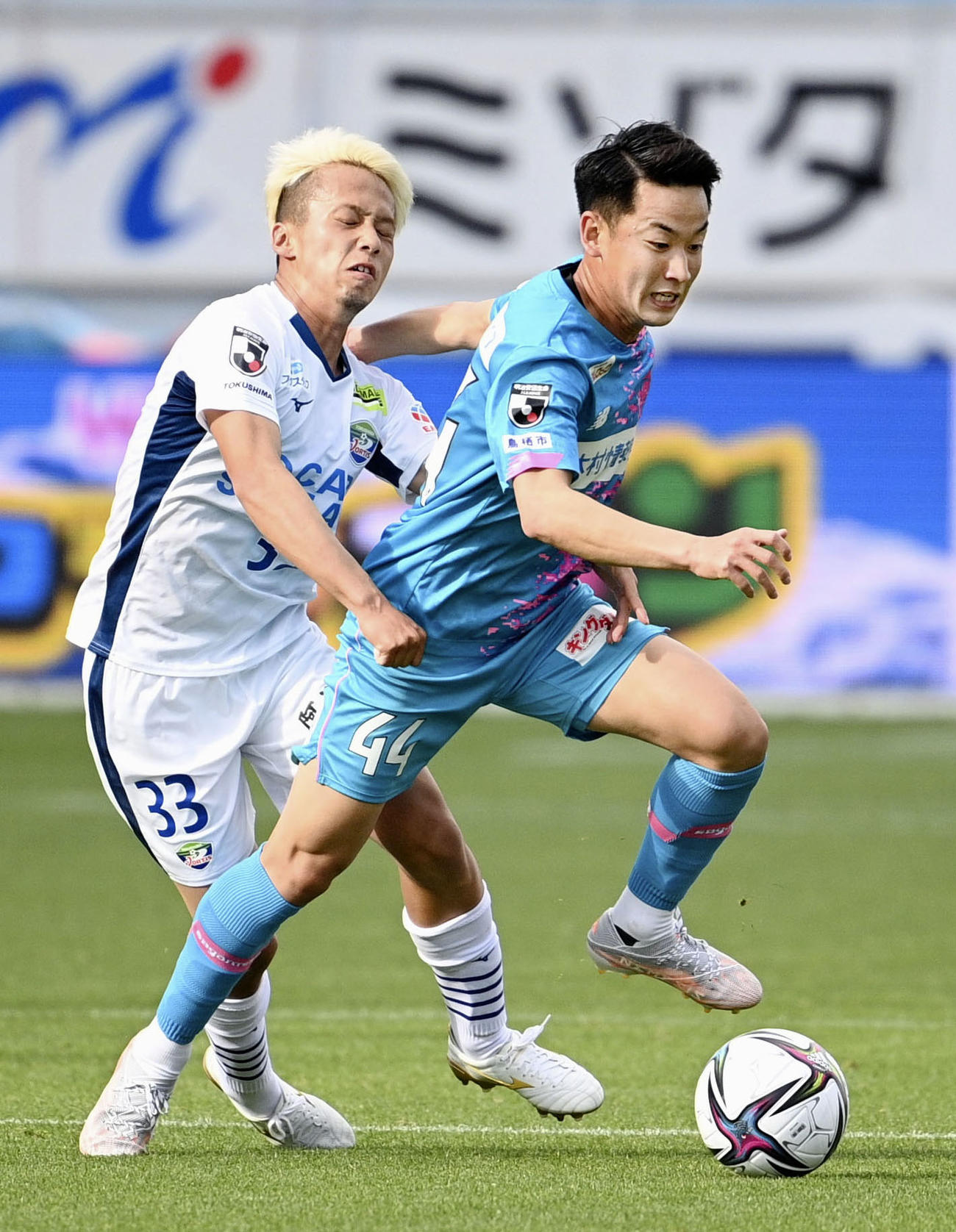 前半、競り合う鳥栖・仙頭（右）と徳島・藤原＝駅スタ（共同）