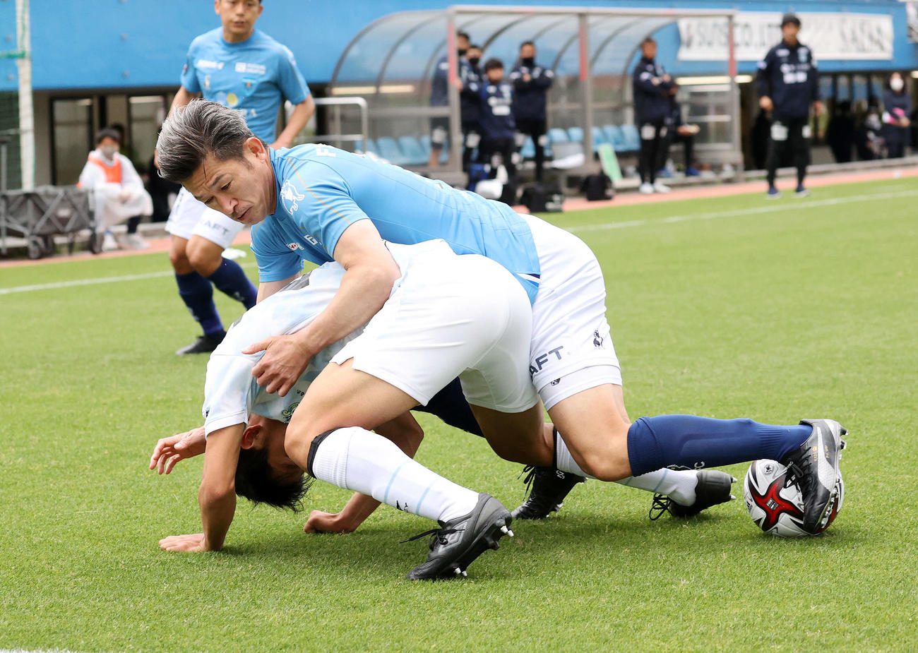 横浜FC対湘南　後半、湘南平岡（下）と競り合う横浜FCカズ（撮影・鈴木正人）