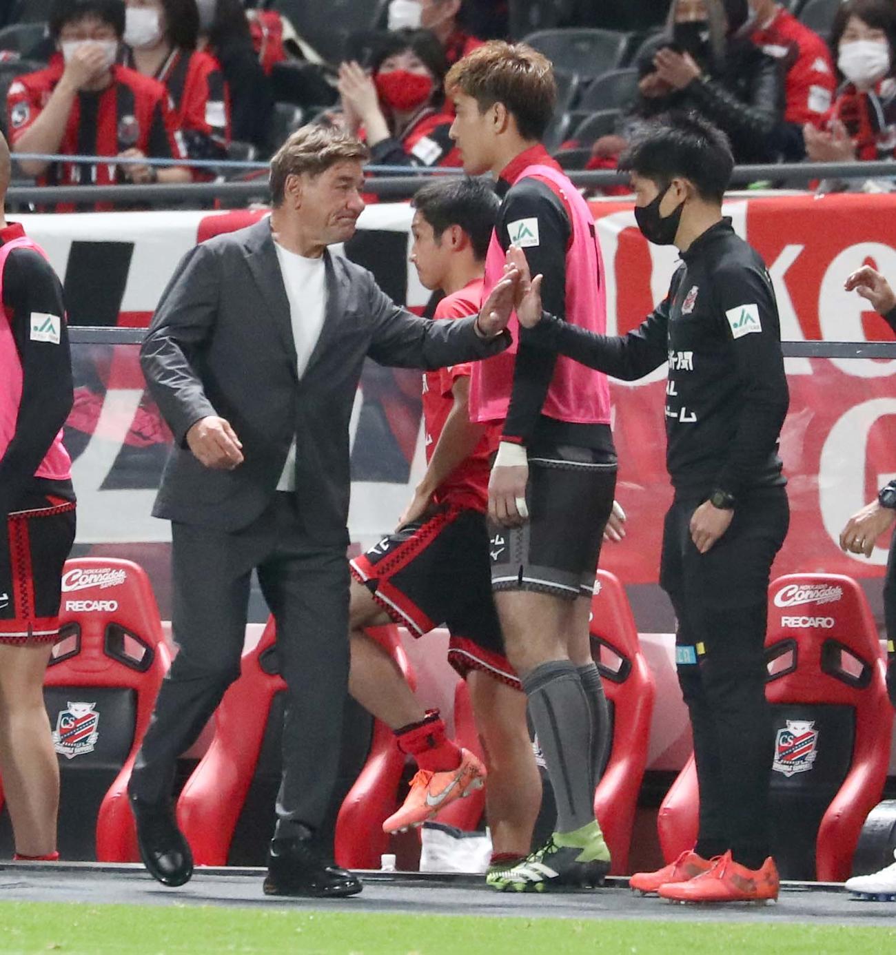 札幌対鳥栖　試合後、選手、スタッフとタッチするペトロビッチ監督（左）（撮影・黒川智章）