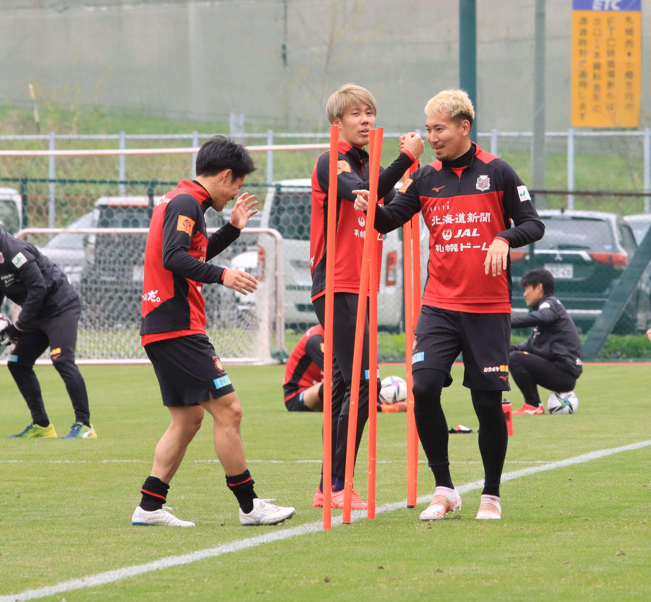 ランニング中に笑顔を見せる札幌DF福森（右）。左はFW小柏、中央はDF田中駿（撮影・保坂果那）