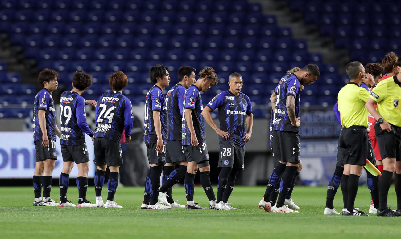 21年5月12日、広島に敗れ肩を落とし整列する宇佐美（中央）らG大阪の選手ら