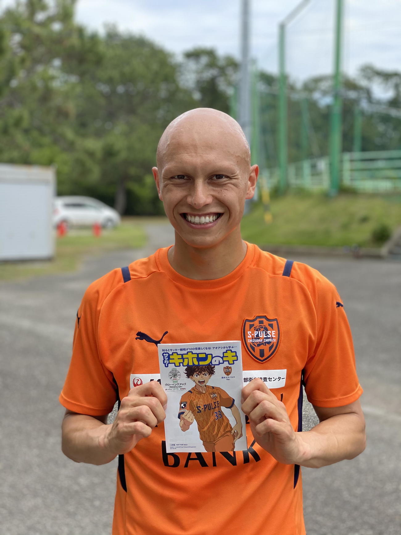 冊子を手に笑顔の清水FWディサロ（Ｃ）S－PULSE