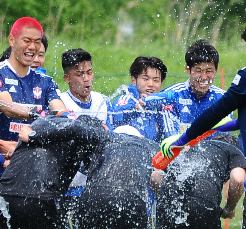 誕生日を迎えたスタッフを手荒に祝福する本間（中央）