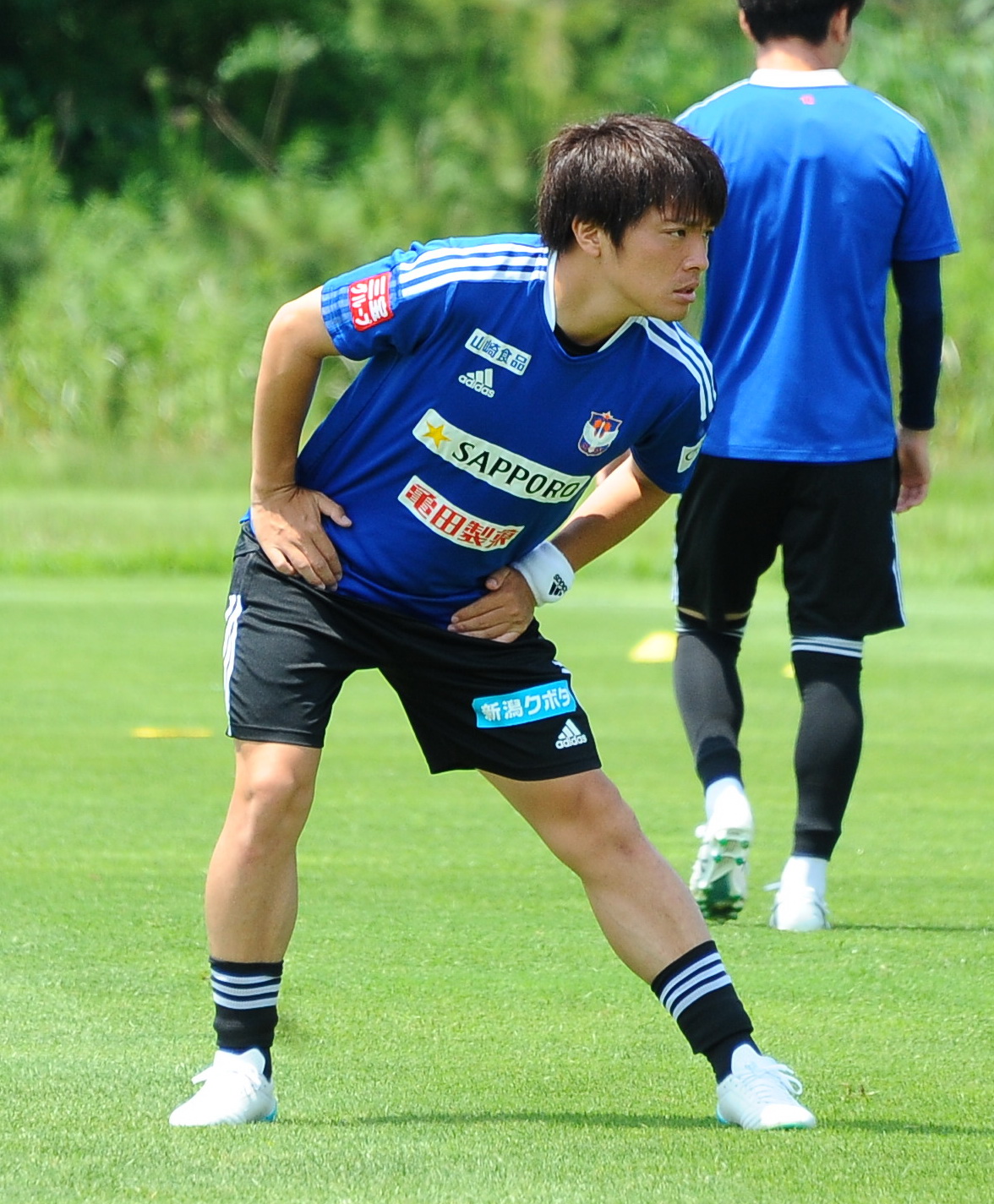 集中した表情でストレッチする高木