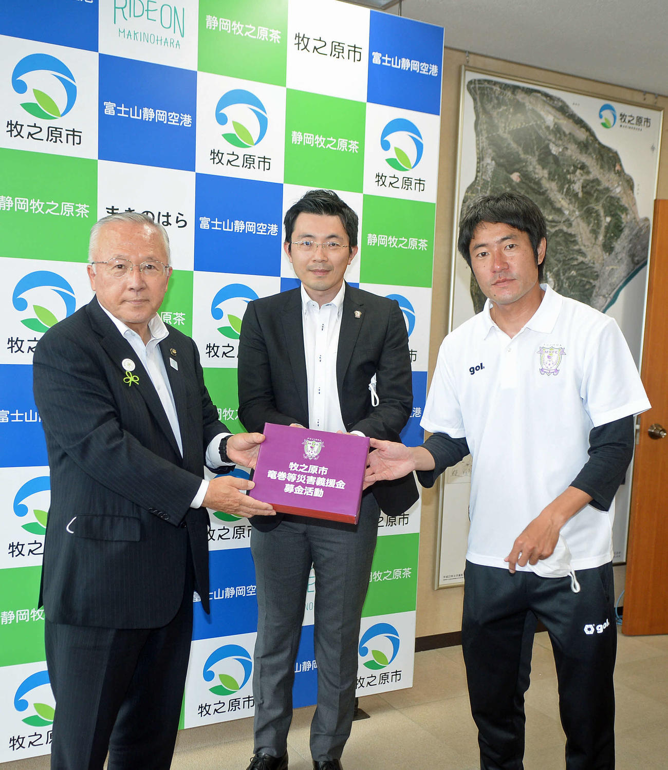 義援金を手に記念撮影する、左から牧之原市の杉本市長、藤枝の徳田社長、MF枝村