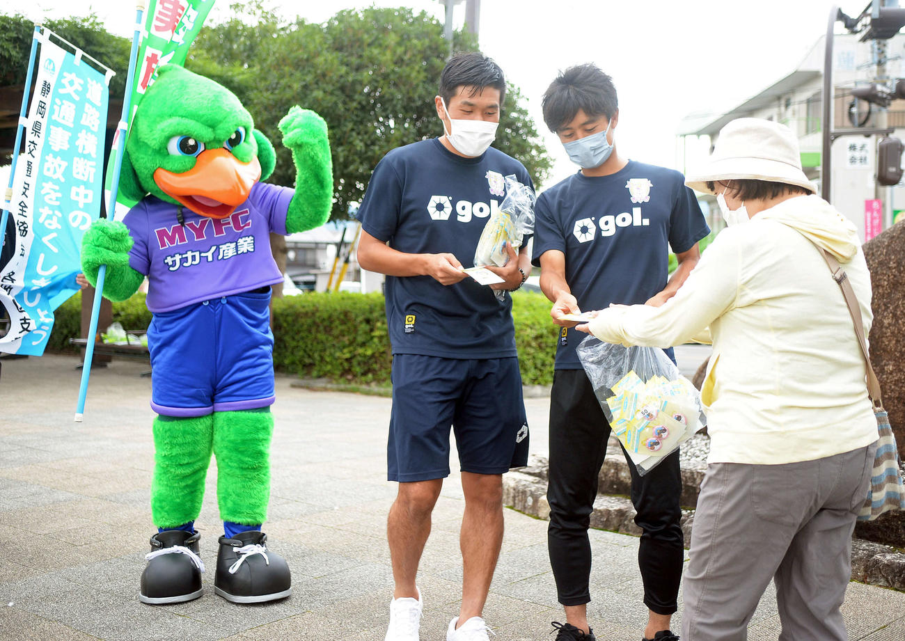 交通安全運動で市民に反射材を配る藤枝FW岩渕（右から2人目）とFW宮本（中央）。左端はマスコットの蹴っとばし小僧