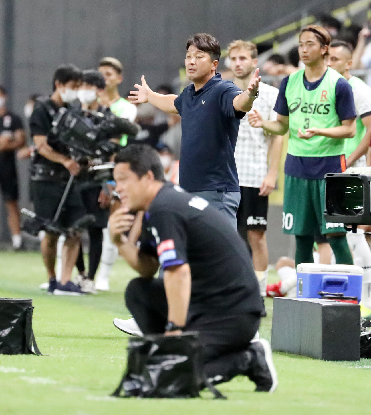 G大阪対神戸　後半ロスタイム、最後のプレーでG大阪に得点が入らず両手を広げ勝利を確信する神戸の三浦監督。手前はひざまずく松波監督（撮影・加藤哉）
