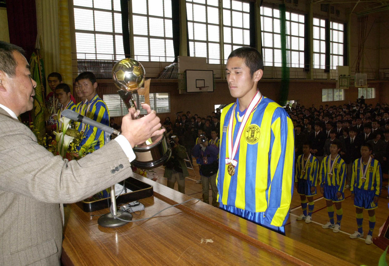 校長の小嶺総監督（左）からトロフィーを授与される松橋章太
