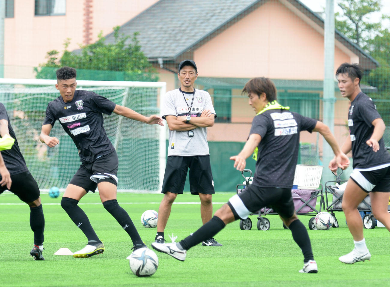 パス回しのメニューで選手の動きを見つめる藤枝の須藤監督（中央）