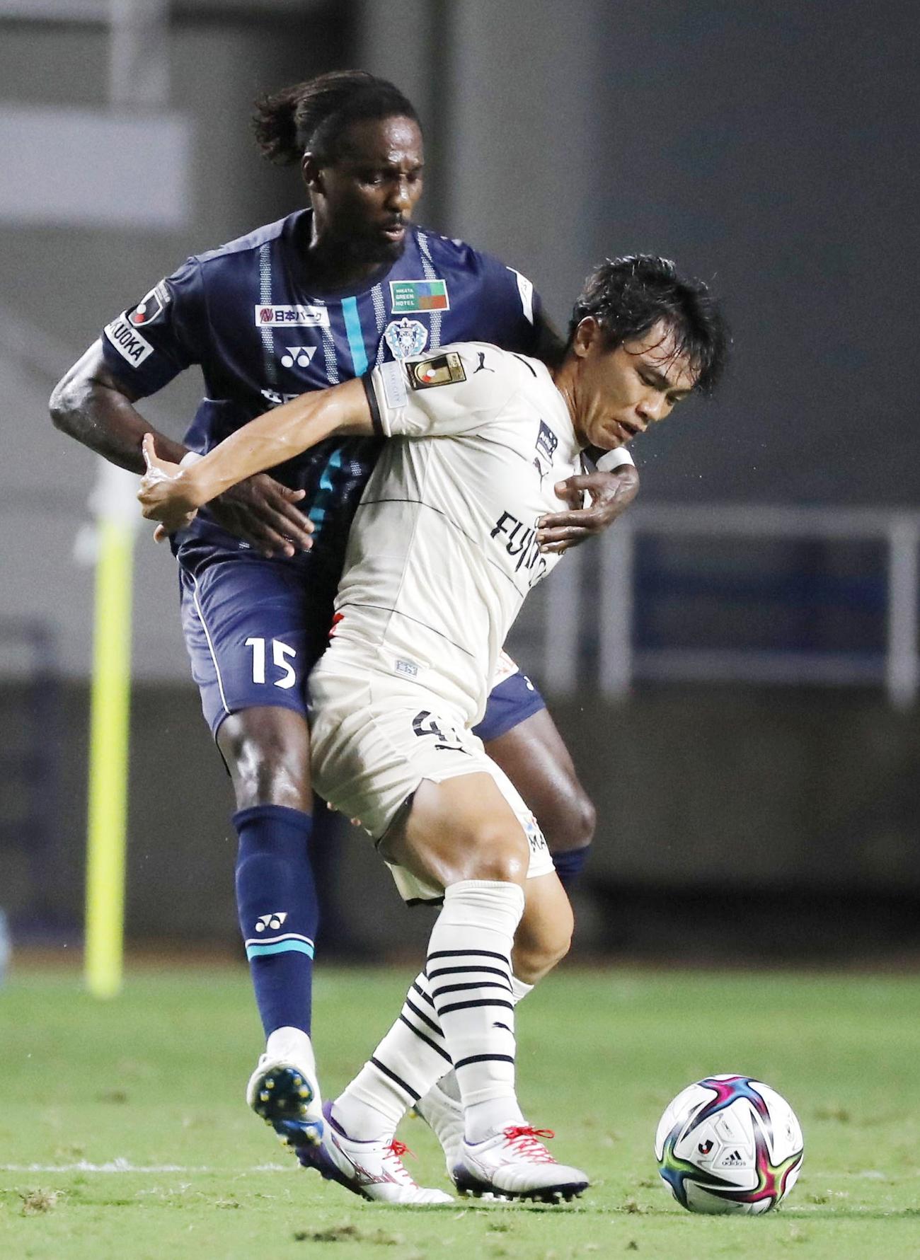 前半、中盤で競り合う福岡・カウエ（左）と川崎・旗手（共同）