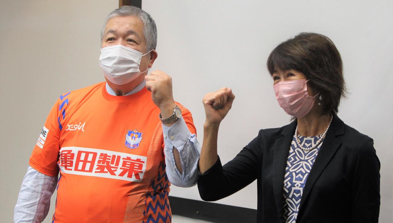 WEリーグ開幕に期待を込めガッツポーズをする岡島チェア（右）と亀田製菓・田中会長
