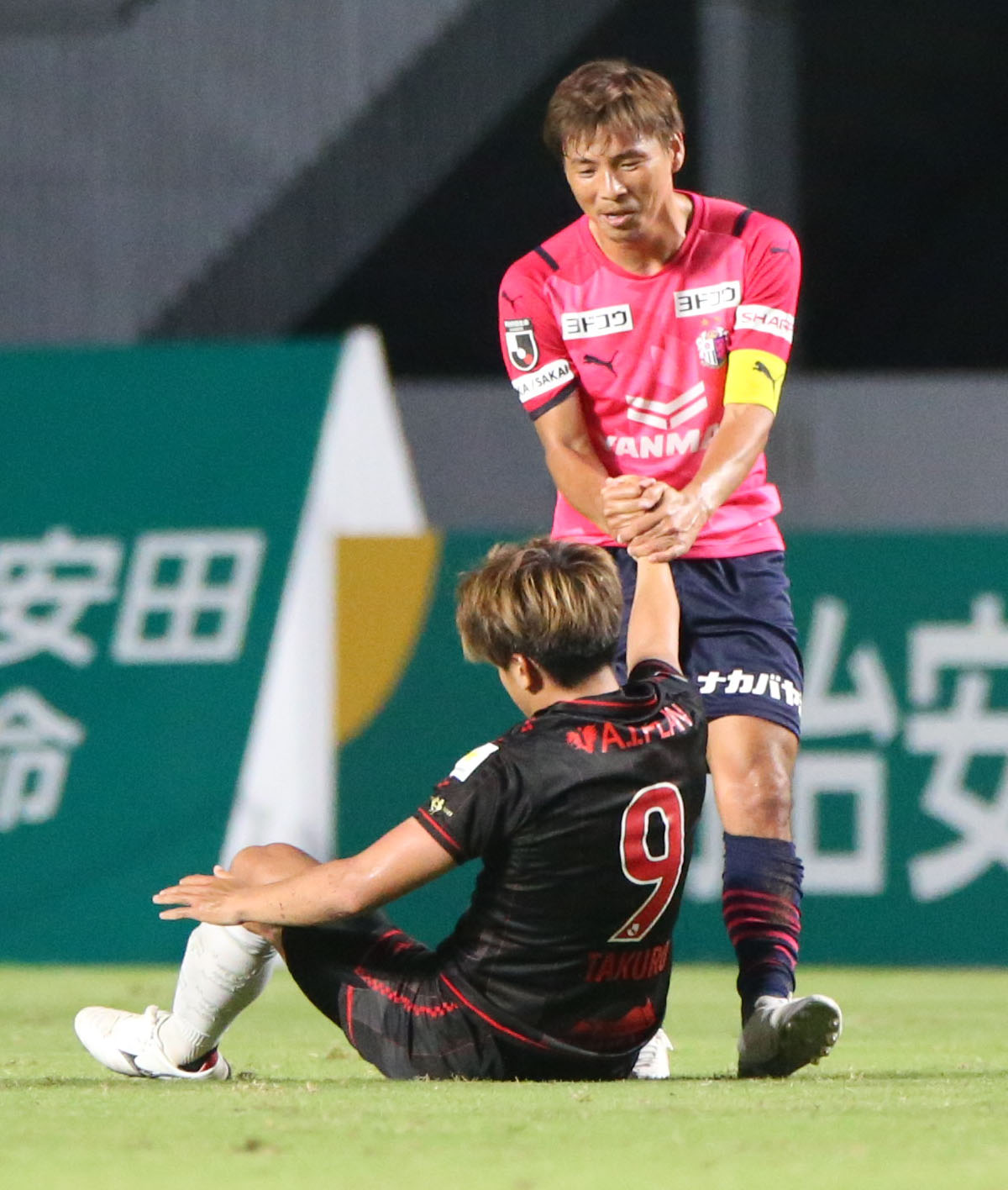 C大阪対札幌　前半、ファウルで倒した札幌金子（手前）を起こすC大阪乾（撮影・上山淳一）