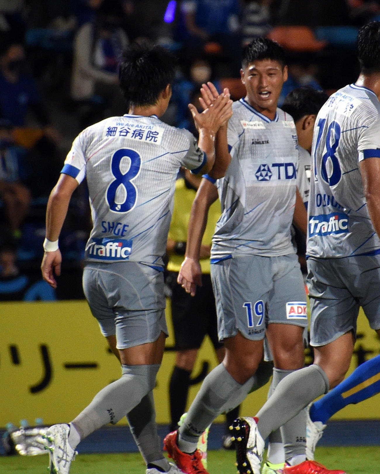 前半36分、追加点を決めてハイタッチする秋田FW武（右）とMF茂
