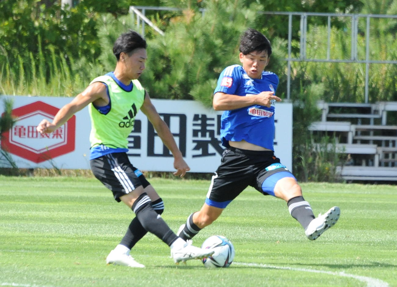ボールを奪いに向かうJ2新潟MF藤原奏哉（右）