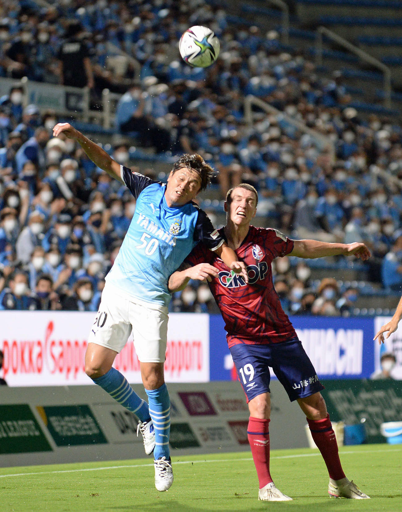 岡山戦　ライン際で競り合う磐田MF遠藤（左）と岡山FWミッチェル・・デューク