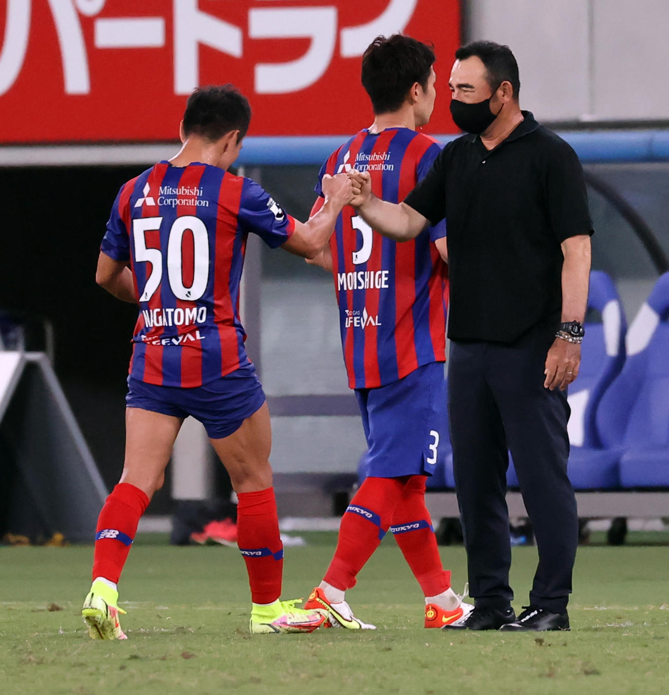 東京対名古屋　1－1の引き分けで、引き揚げる東京長友（左）らをグータッチで迎える長谷川監督（撮影・浅見桂子）