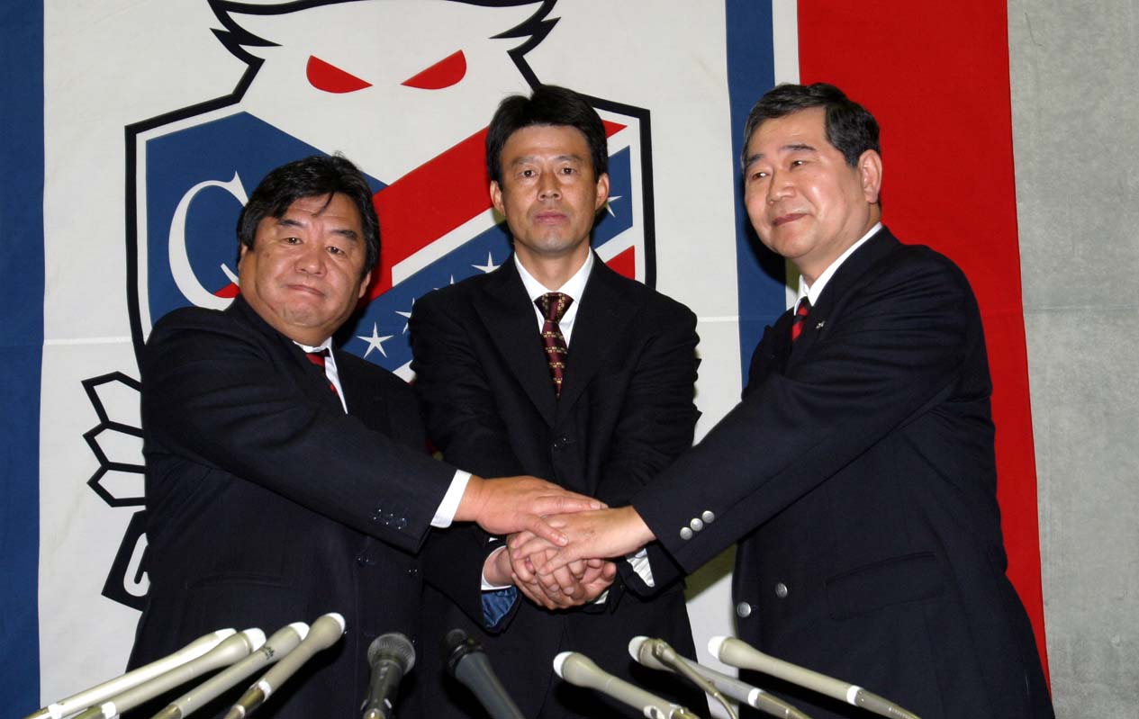 04年、柳下監督（中央）の就任会見で握手する石水氏（左）