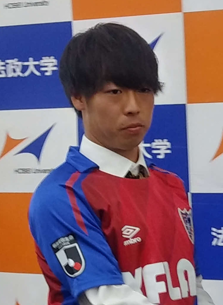 FC東京の強化部の羽生直剛氏（右）と握手する法大MF紺野和也