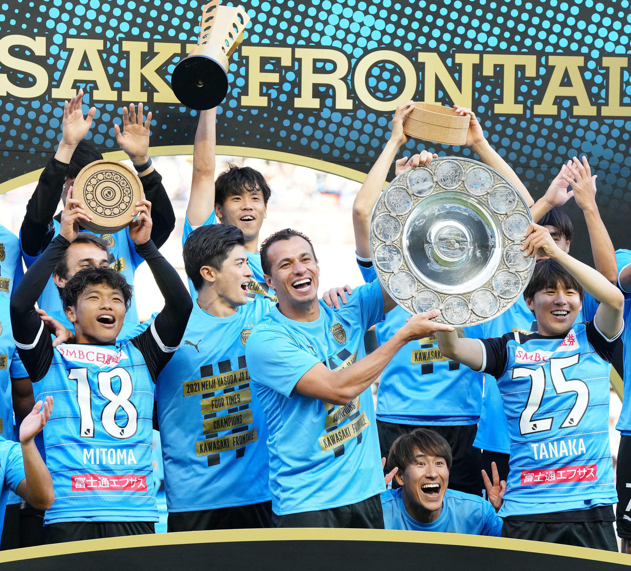 川崎F対浦和　優勝を決めシャーレ（銀皿）を掲げる川崎Fダミアン（中央右）と田中のユニホームを着た脇坂（右端）。左端は三笘のユニホームを着た旗手（2021年11月3日撮影）