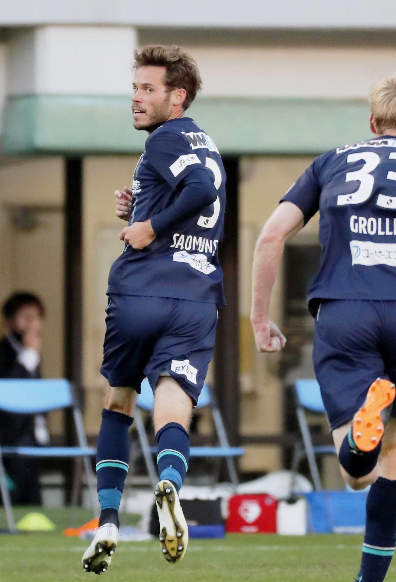 試合終了間際、シュートが横浜FCのオウンゴールを誘い同点とし、駆けだす福岡・サロモンソン（左）（共同）