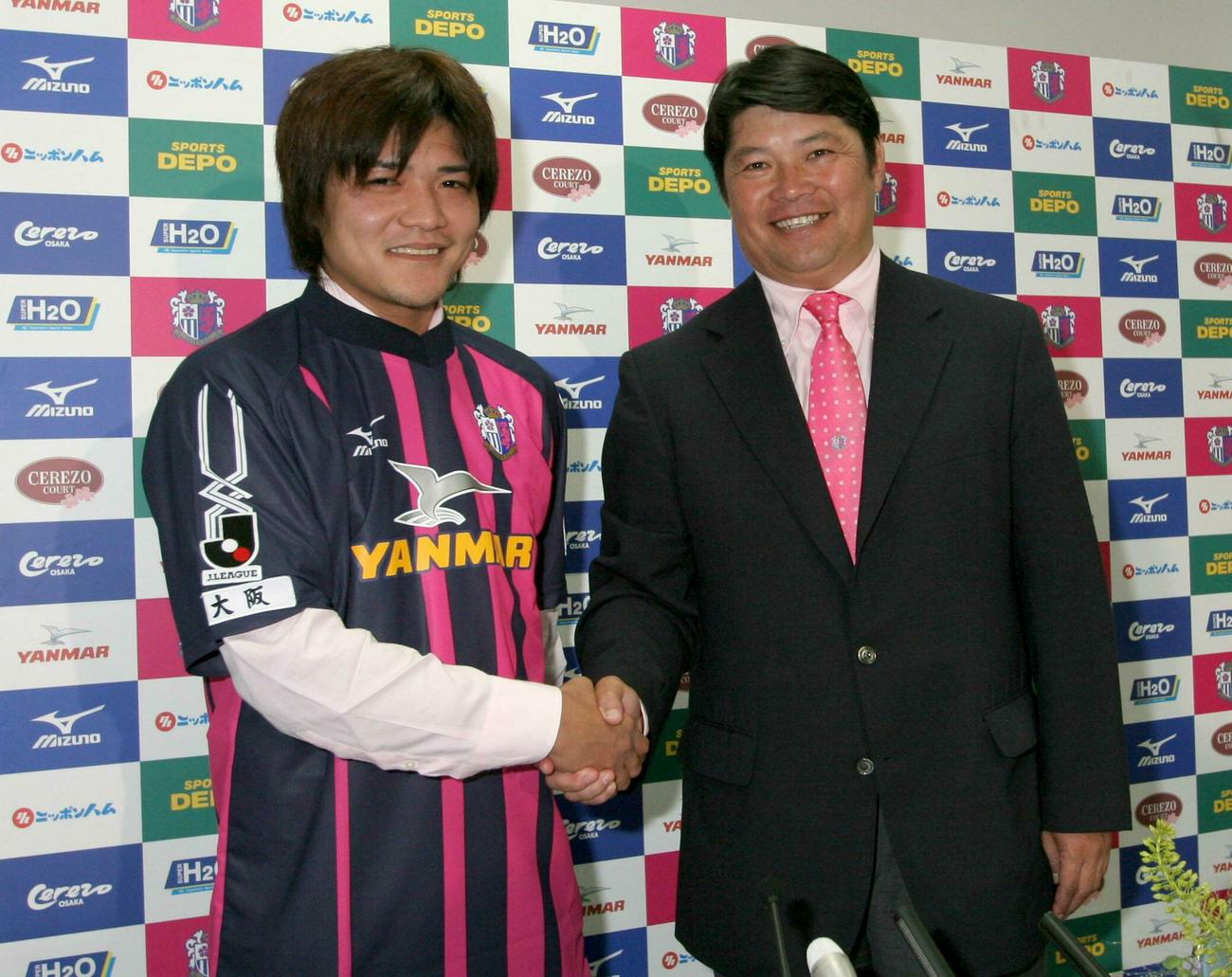 06年　C大阪復帰会見　再び桜のユニホームを着たFW大久保嘉人（左）は西村昭宏GMと握手を交わし笑顔で入団発表