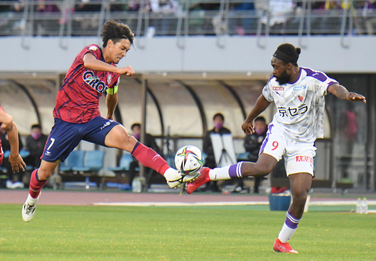 岡山対京都　前半、ボールを奪い合う岡山・白井永地（左）と京都ピーター　ウタカ（撮影・滝沢美穂子）