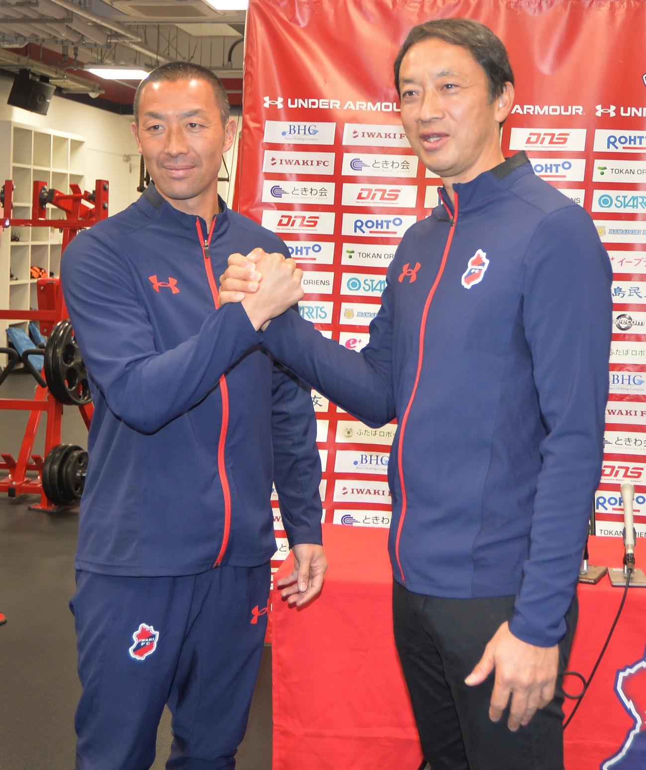 Jリーグ参入が決まり、がっちりと握手を交わすいわきFC田村監督（左）と大倉社長