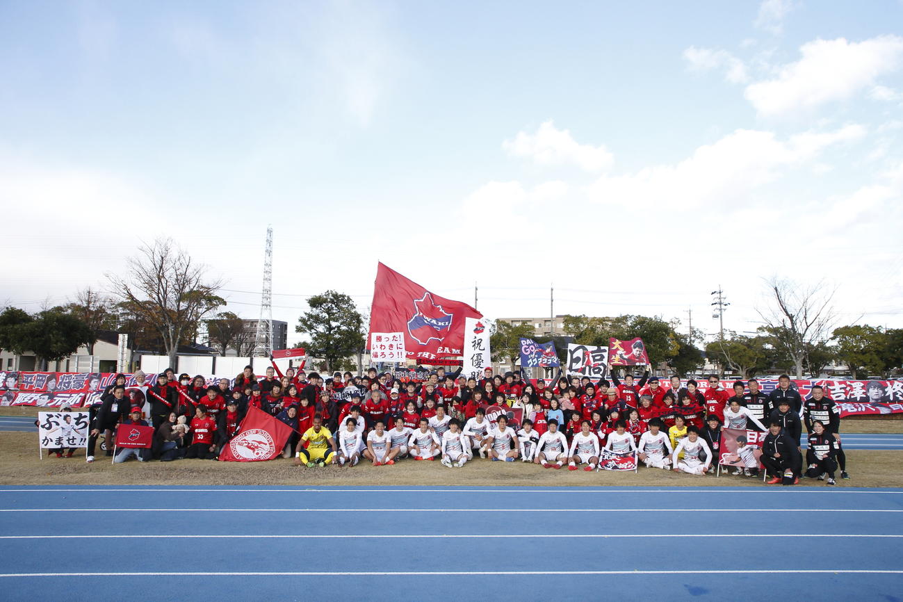 JFL優勝を決め、応援に駆けつけたサポーターとともに笑顔で記念撮影するいわきFCイレブン（いわきFC提供）