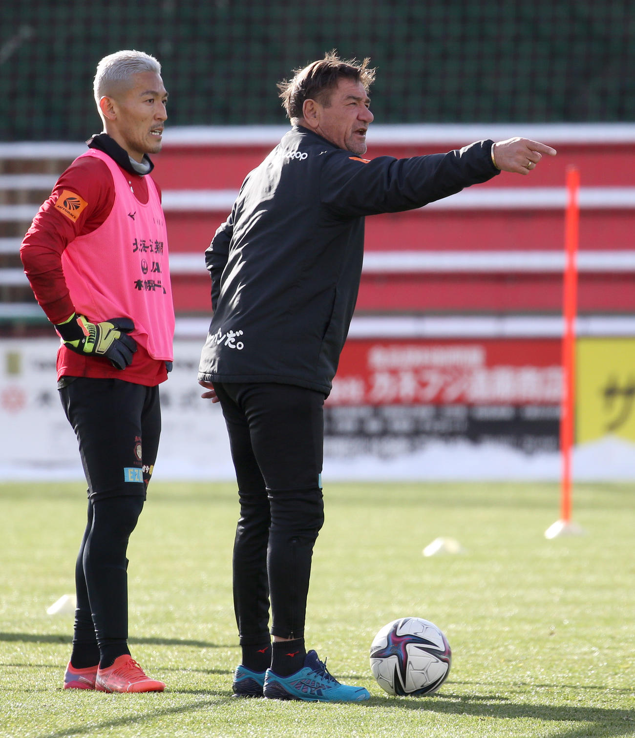 練習中、言葉を交わす札幌菅野（左）とペトロビッチ監督（撮影・佐藤翔太）