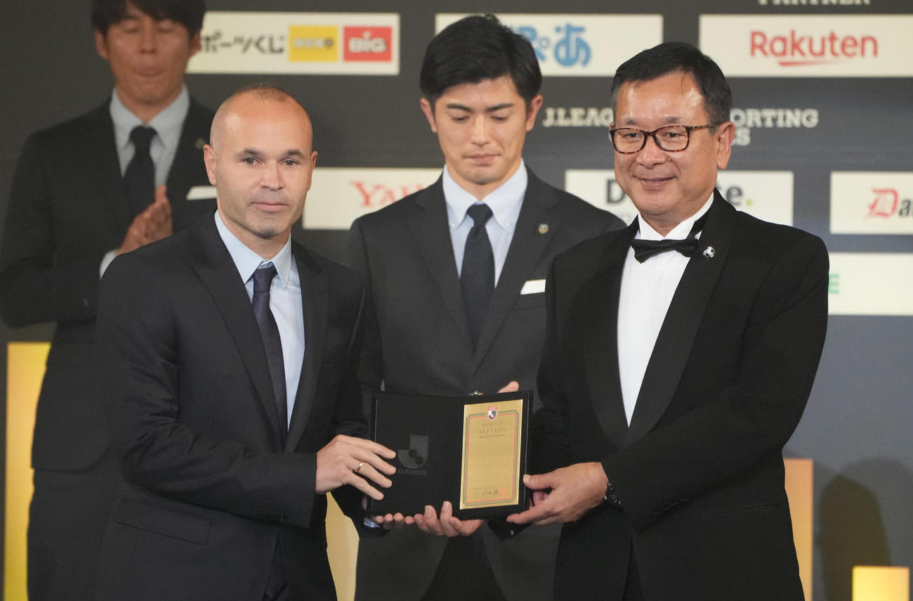 ベストイレブンに選ばれ、代表してJリーグ村井チェアマン（右）から盾を受け取る神戸イニエスタ（撮影・鈴木みどり）
