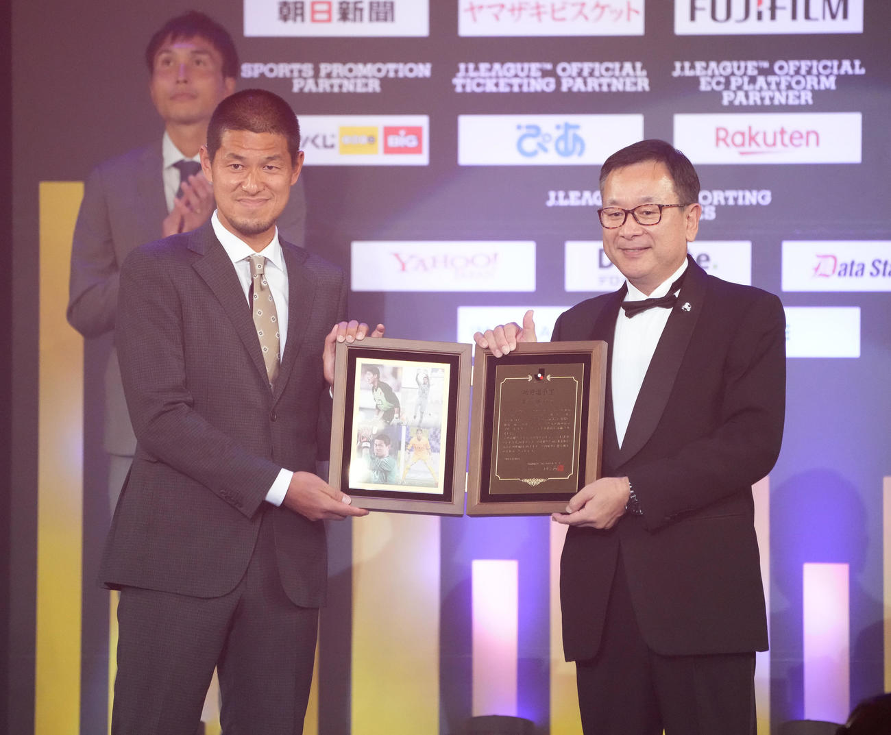 功労選手賞を受賞し、代表してJリーグ村井チェアマン（右）から盾を受け取る曽ケ端氏（撮影・鈴木みどり）