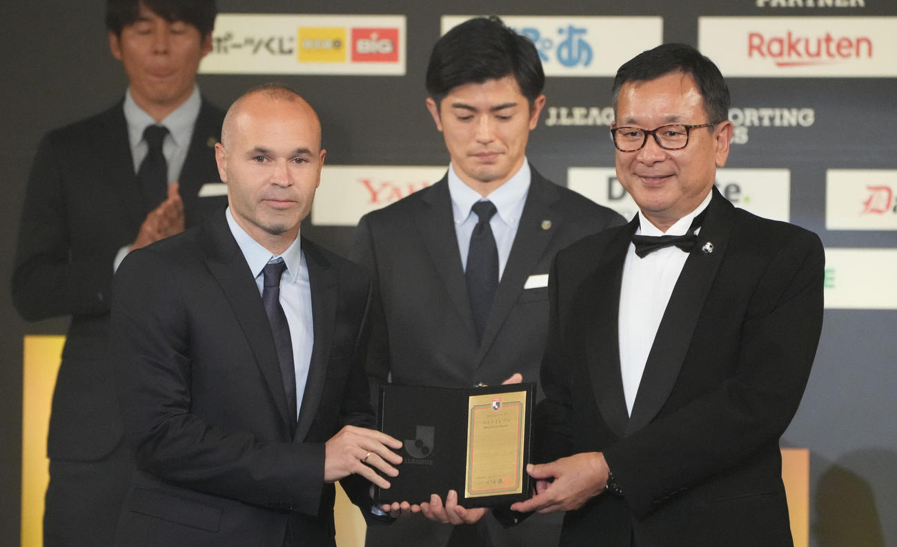 ベストイレブンに選ばれ、代表してJリーグ村井チェアマン（右）から盾を受け取る神戸イニエスタ（撮影・鈴木みどり）