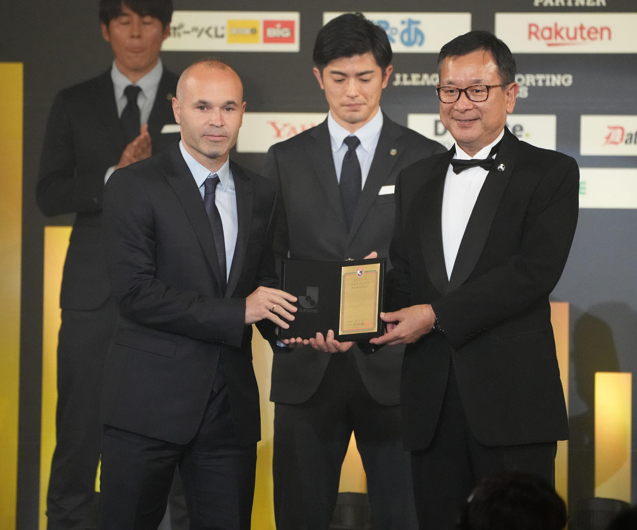 ベストイレブンに選ばれ、代表してJリーグ村井チェアマン（右）から盾を受け取る神戸イニエスタ（撮影・鈴木みどり）