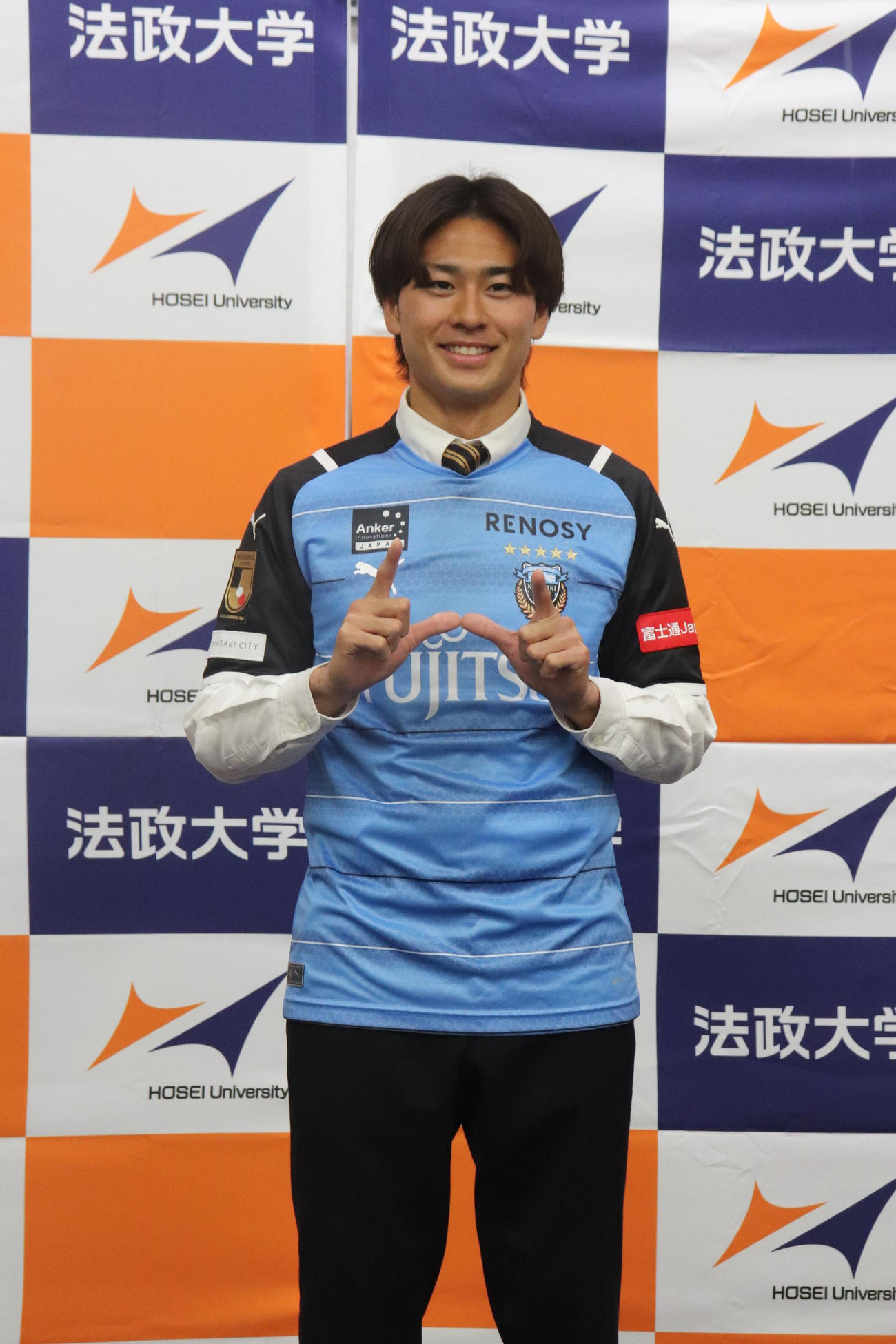 川崎Fに内定し会見に臨んだMF松井蓮之は法大ののHポーズを披露
