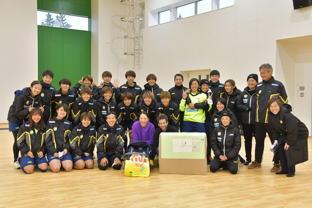第1子出産後初めて練習に参加し、チームメートからお祝いの品を受け取った千葉FW大滝（前列中央）。右は夫　（C）JEFUNITED