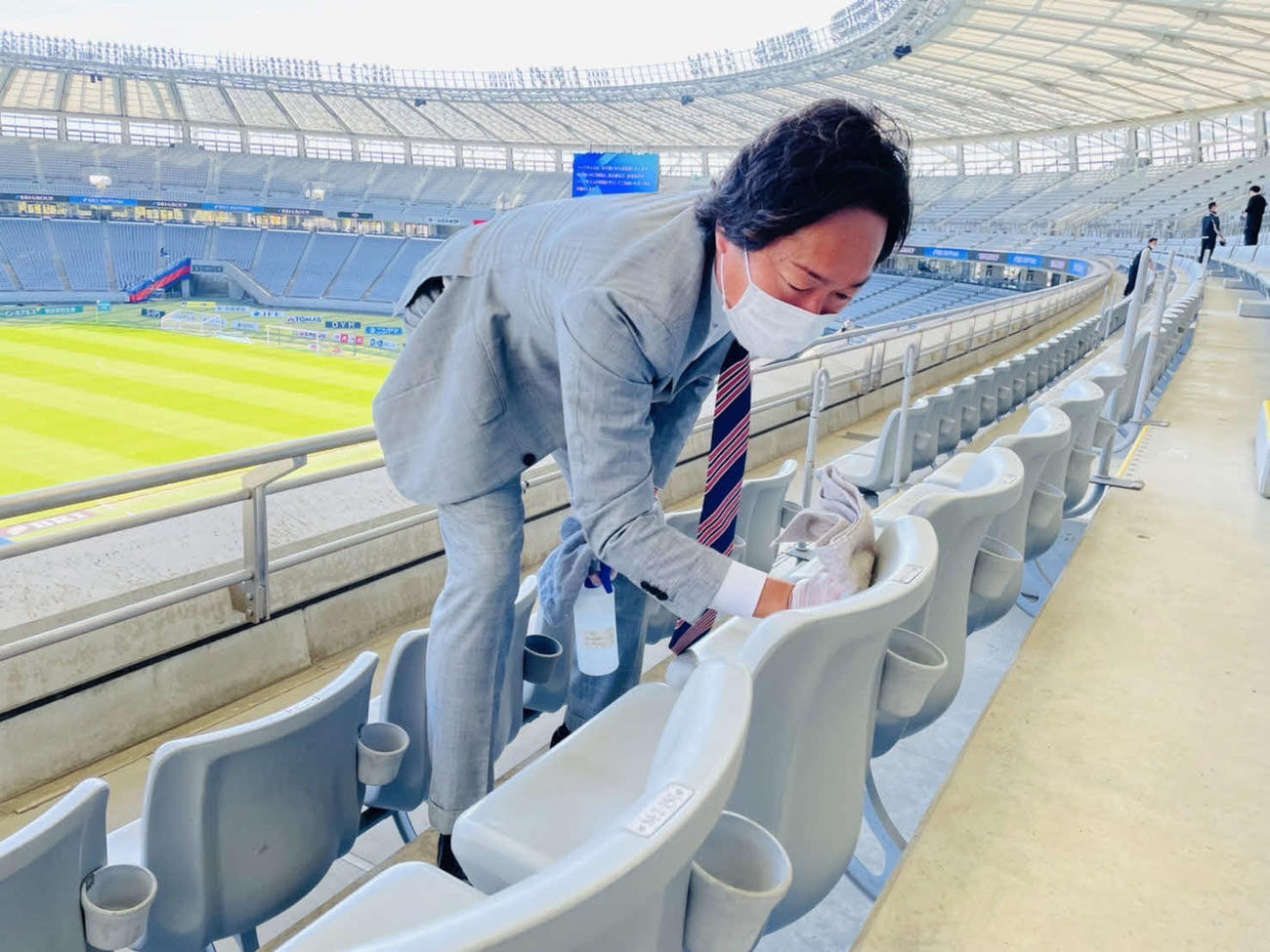 試合前にスタンドの椅子を拭いて回る石川直宏CC＝クラブ提供