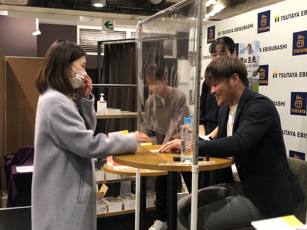 難波で行われたサイン会で涙ぐむ女性サポーターにサインをする大久保嘉人（撮影・益子浩一）