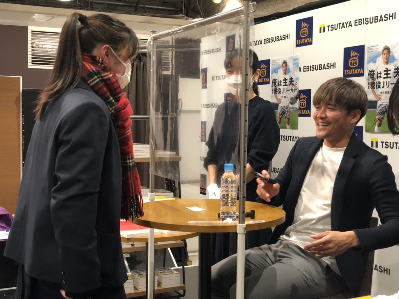 難波で行われた出版記念イベントでサポーターにサインをする大久保嘉人（撮影・益子浩一）