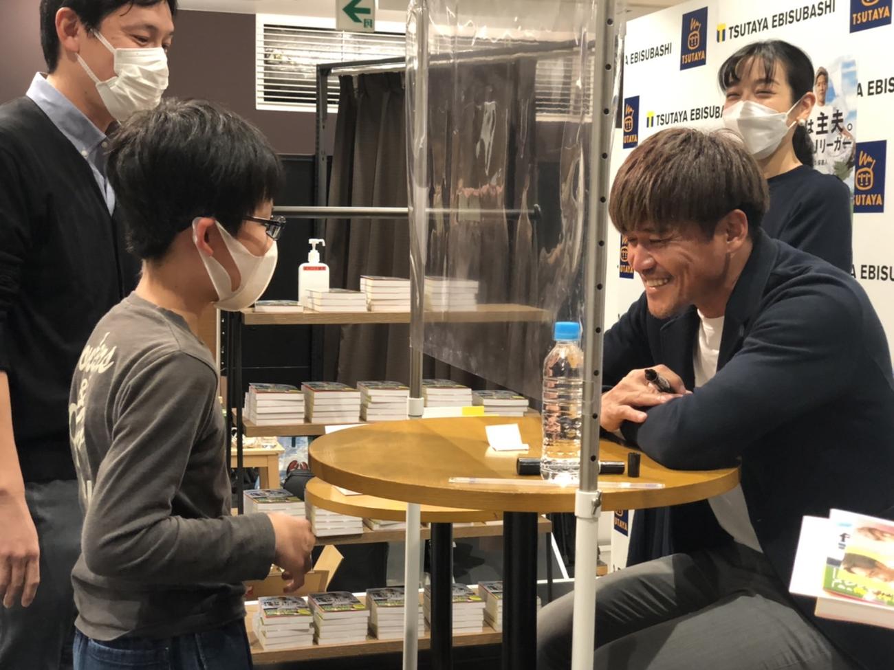 難波で行われた出版記念イベントでサポーターにサインをする大久保嘉人（撮影・益子浩一）