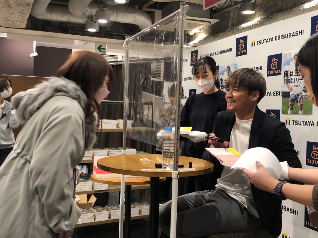 難波で行われた出版記念イベントでサポーターにサインをする大久保嘉人（撮影・益子浩一）