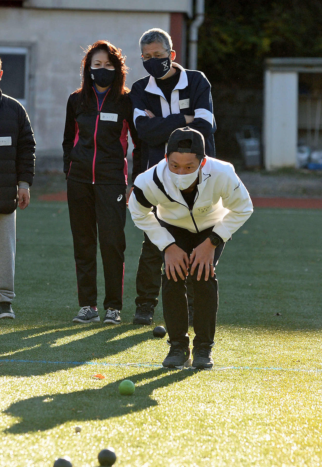 ペタンクを真剣な表情で行う松岡氏（手前）