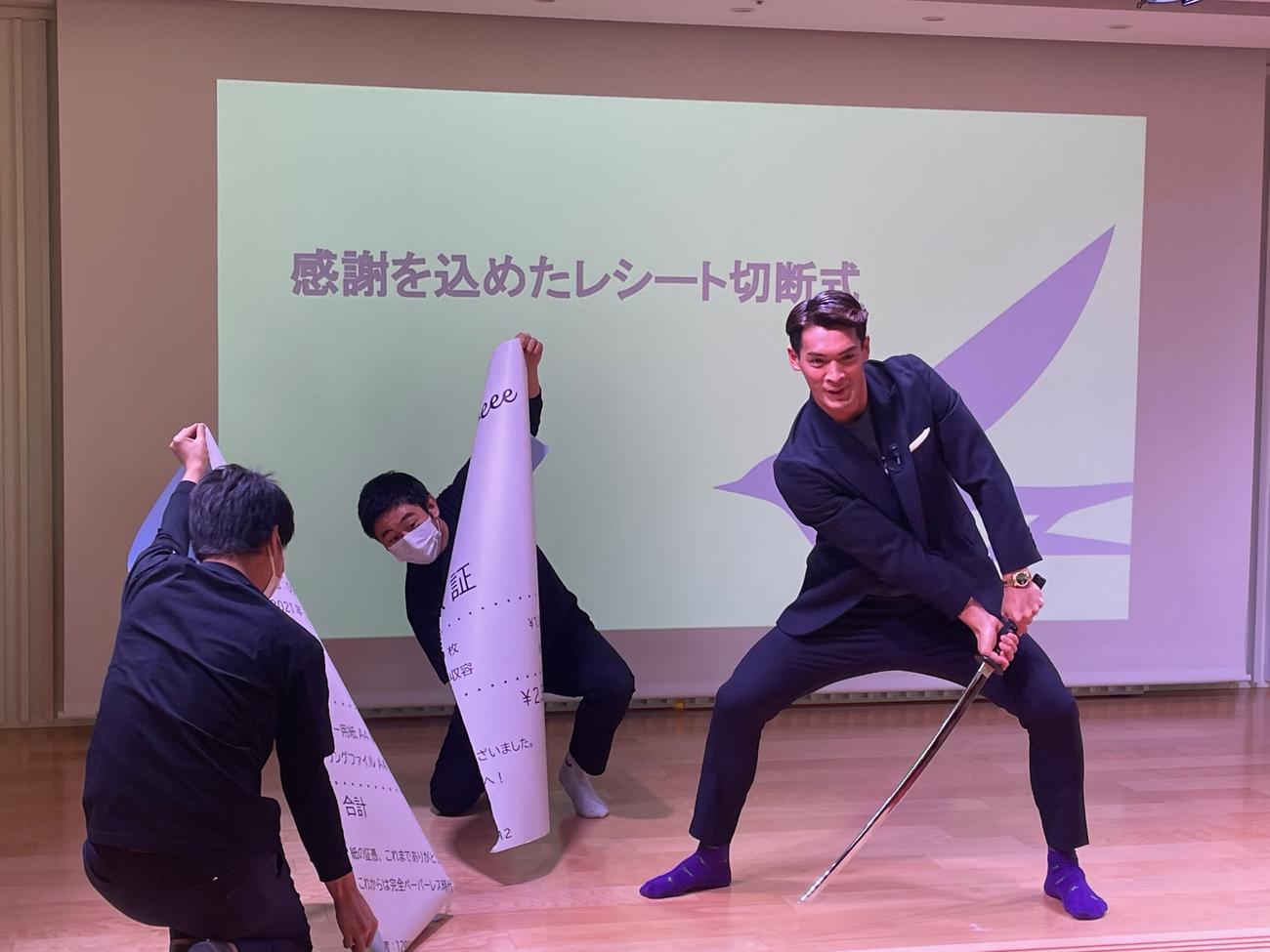 freee社の「さよなら、レシート感謝祭」に出席し、巨大なレシートを斬り終え、満足げな槙野智章