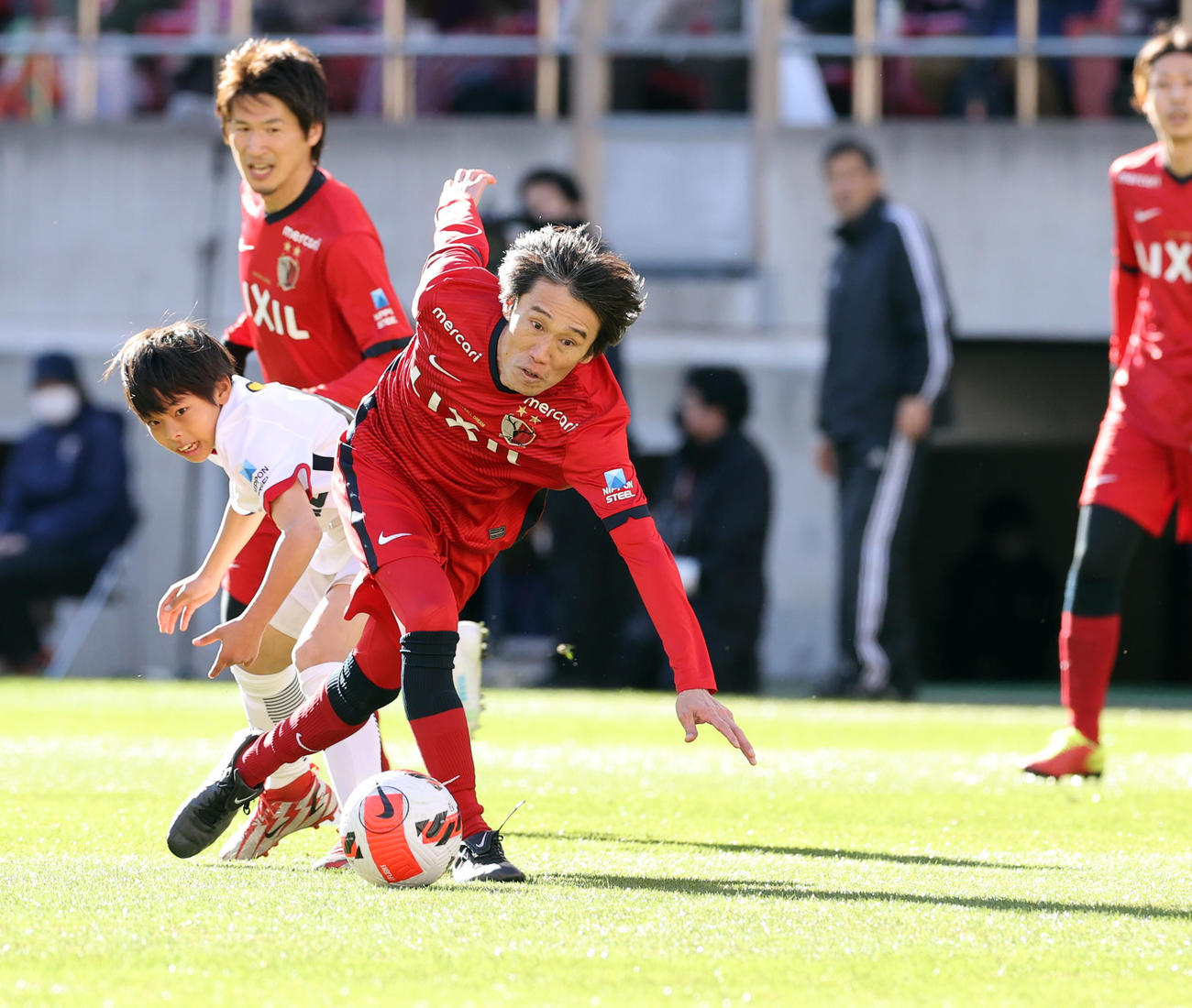 鹿島OB対鹿島アカデミー　30分マッチでアカデミーの選手とボールを競り合う熊谷（手前）（撮影・浅見桂子）