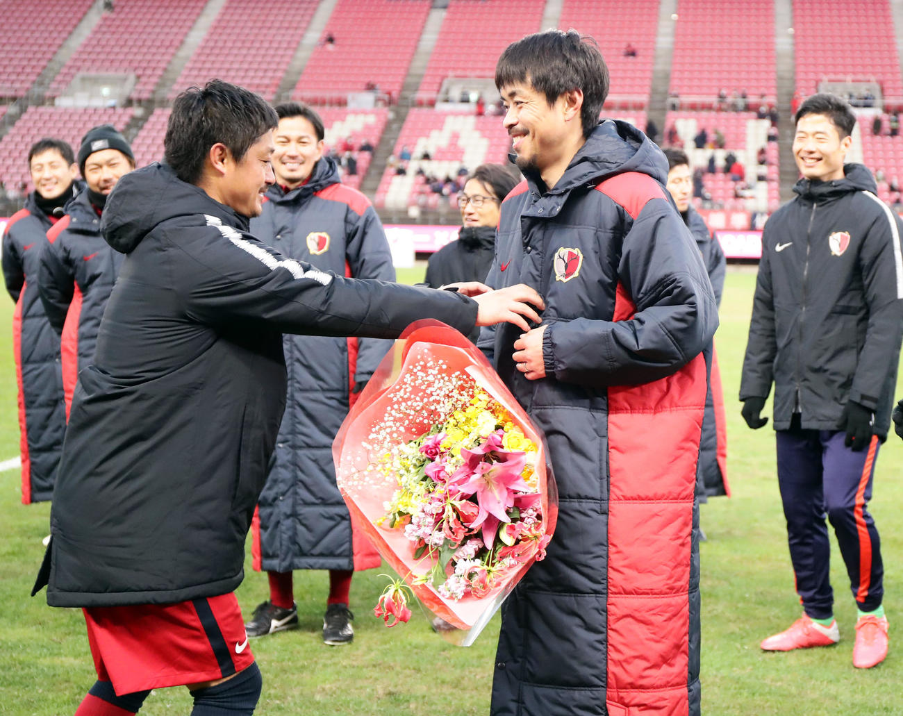 鹿島OB対鹿島アカデミー　現役引退を表明していた青木（右）は古巣鹿島で小笠原（左）から花束を贈られ笑顔（撮影・浅見桂子）